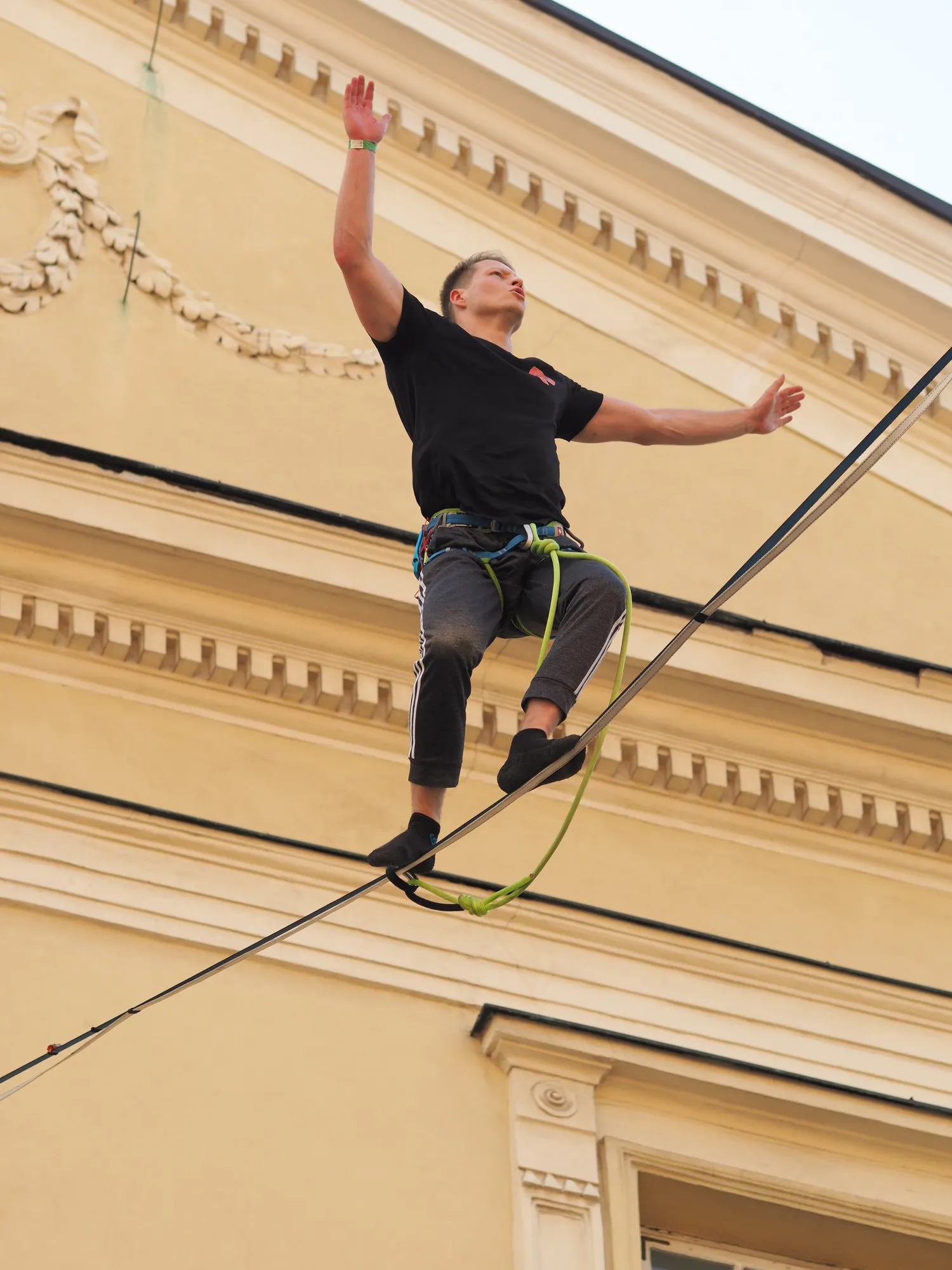 Balancing on a highline in front of a yellow building