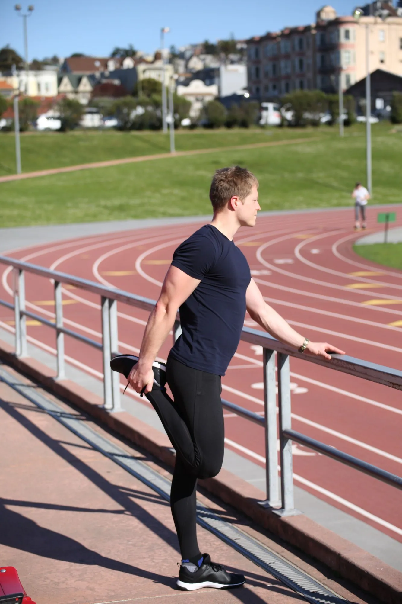 Stretching beside an outdoor running track